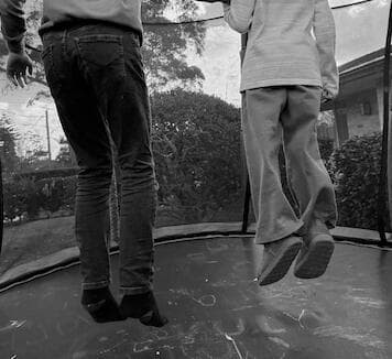 Children bouncing on a trampoline in a garden